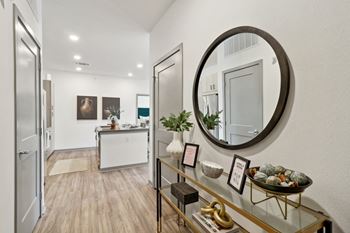 A living room with an oval mirror and a glass display case